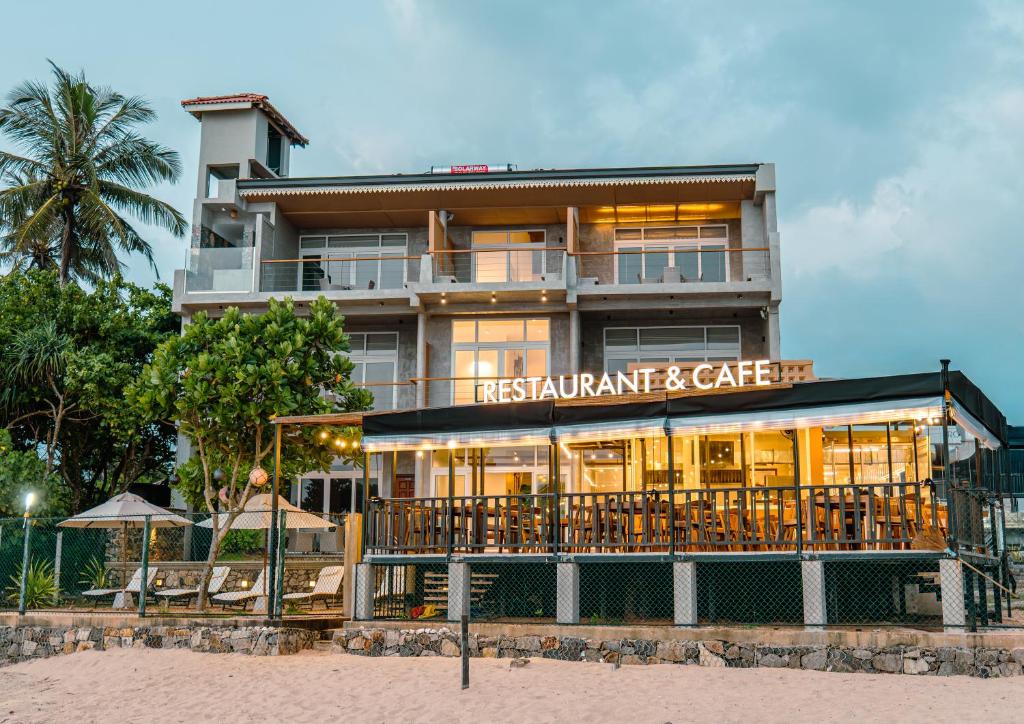 a building with a restaurant on the beach at At Kelly's Ambalangoda in Ambalangoda
