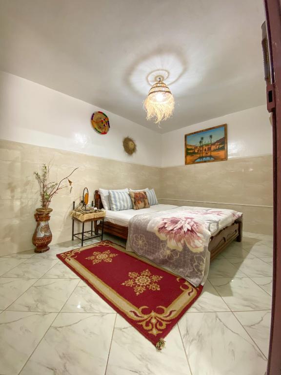 a bedroom with a bed and a rug on the floor at Dallas Surf Apartment in Agadir