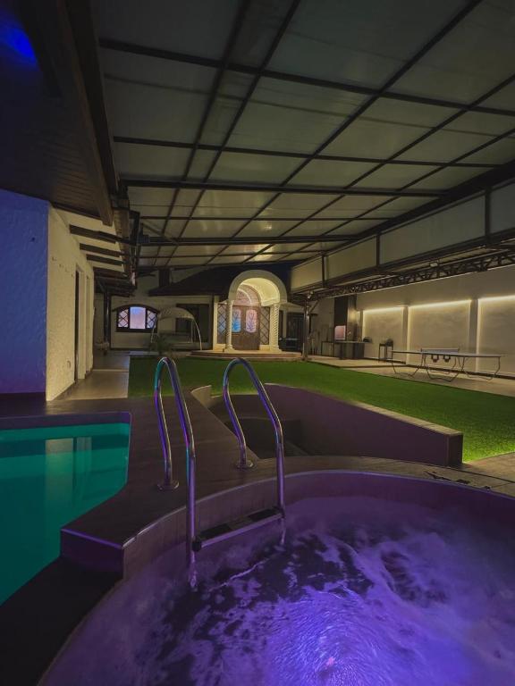 a large hot tub in a room with a pool at TheBunker in Cochabamba