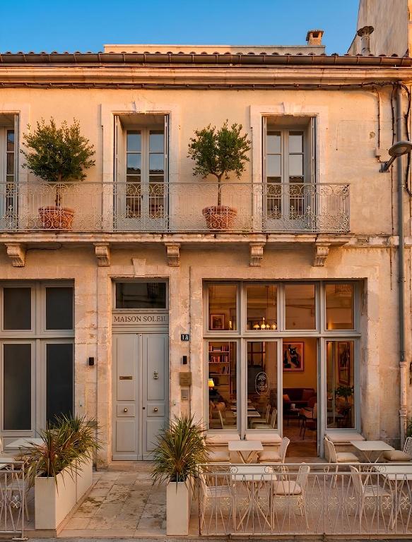 a building with tables and chairs in front of it at Hotel M Soleil - Montpellier Centre Saint Roch in Montpellier