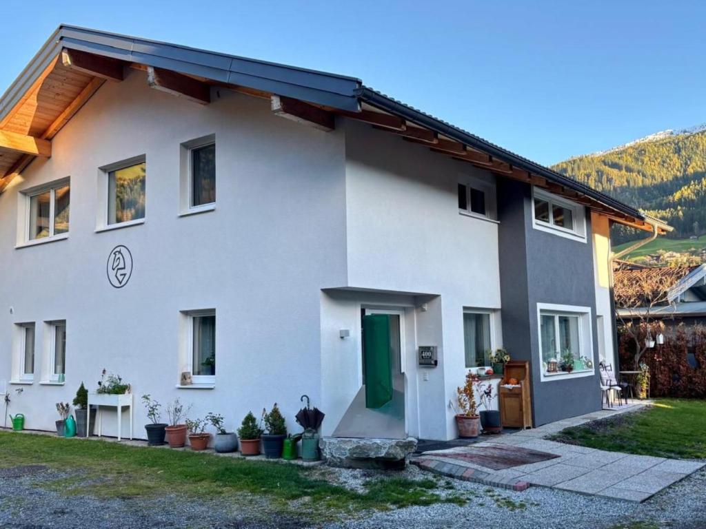a white house with a green door and some plants at Smaragdherz in Brandberg