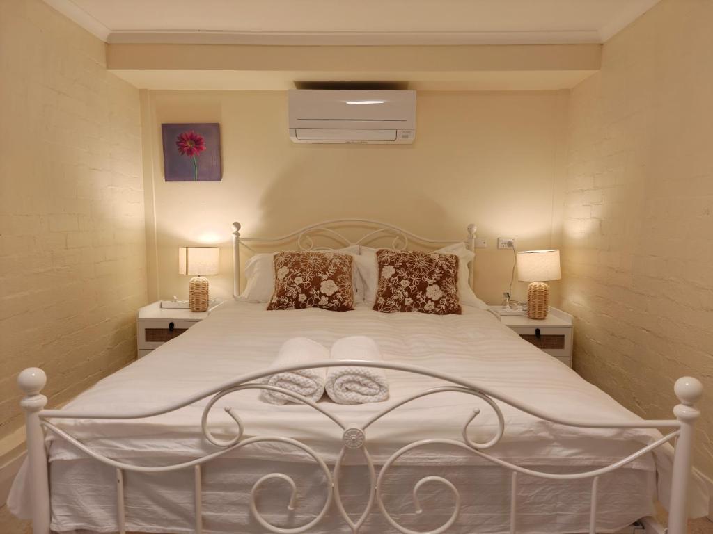 a bedroom with a white bed with two night stands at Tranquil Suites in Heart of Leura 3 Minutes to Shops in Leura