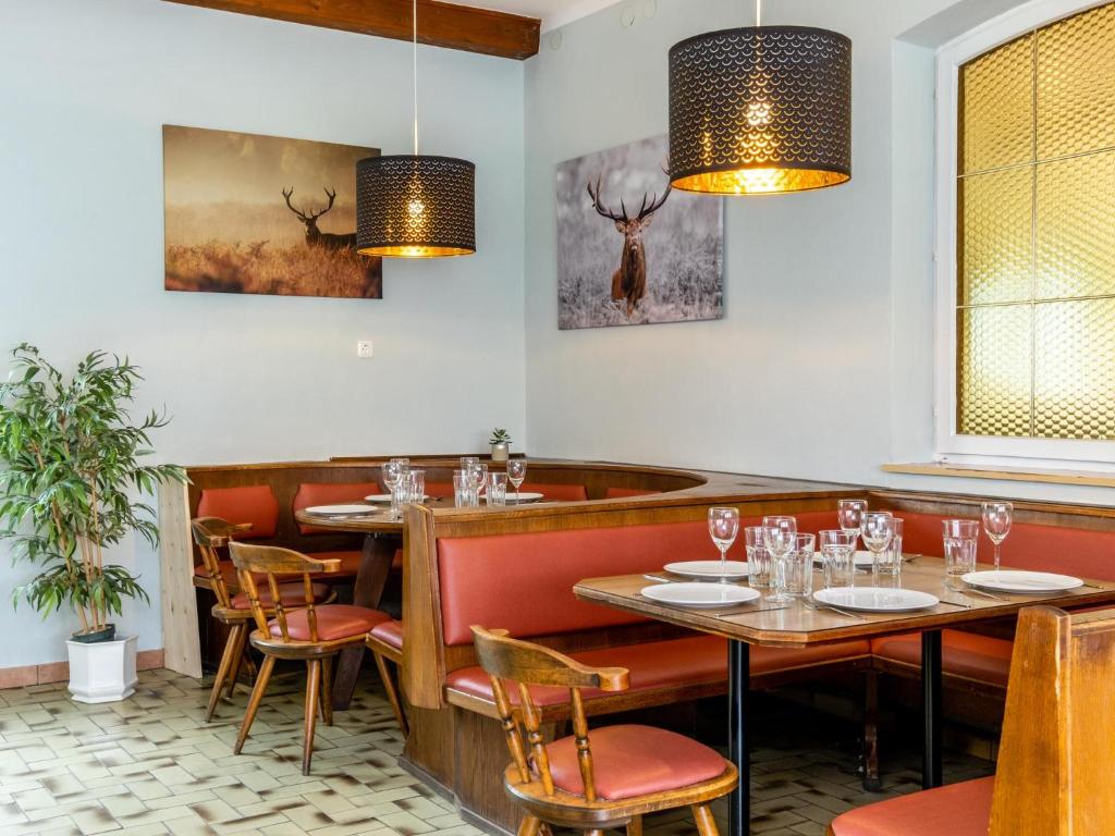 a restaurant with tables and chairs and paintings on the wall at Haslau Large in Hopfgarten im Brixental