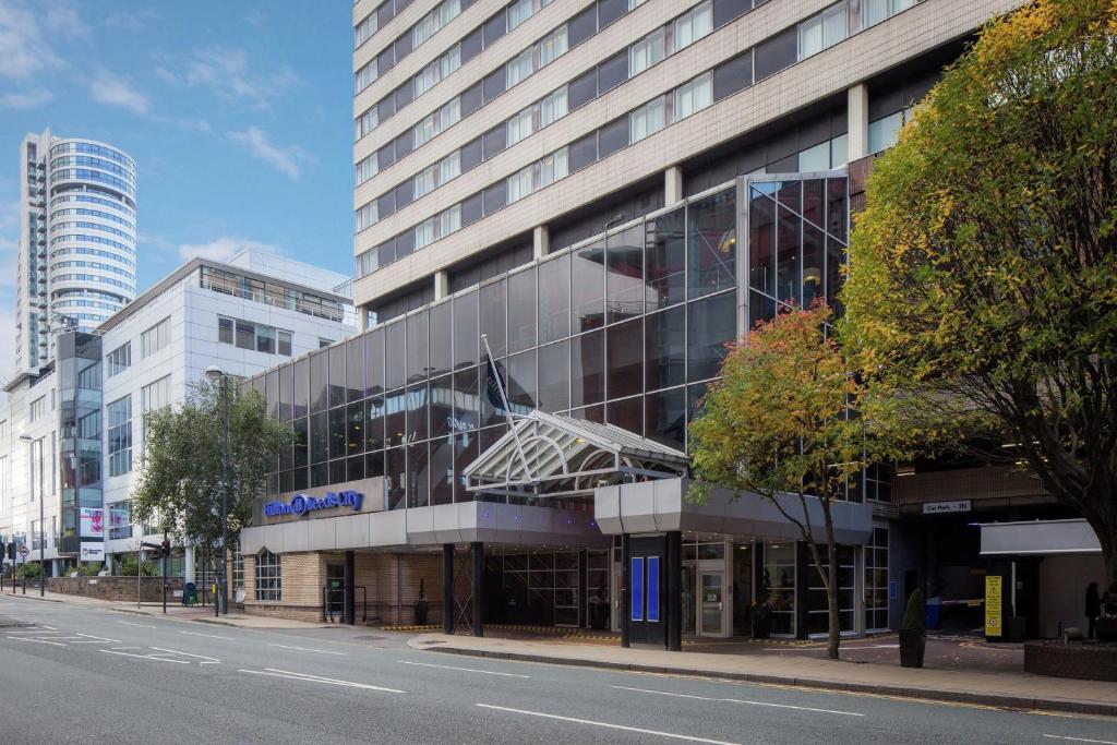 a large glass building on the side of a street at Hilton Leeds City in Leeds