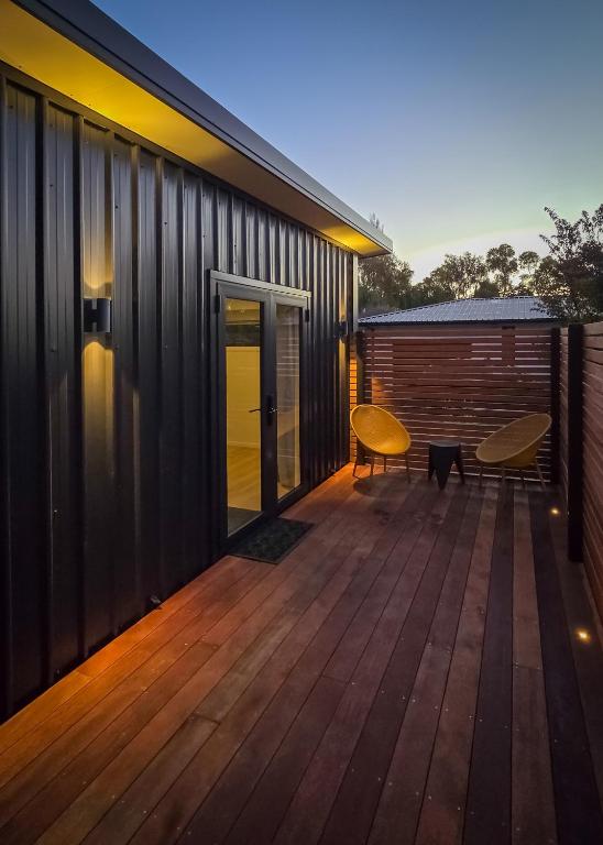 a wooden deck with a bench on a house at Guesthouse on Gardiners in Christchurch