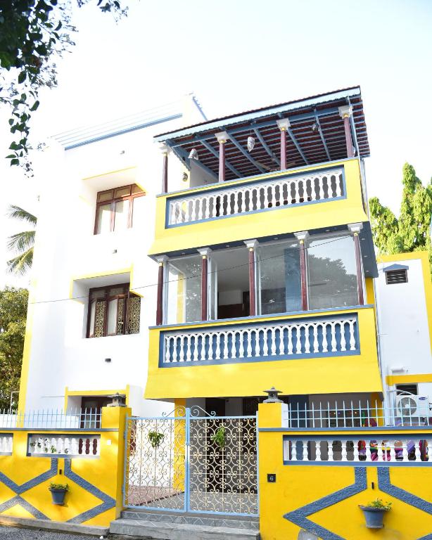 a yellow house with a fence in front of it at La Maison Mira in Pondicherry
