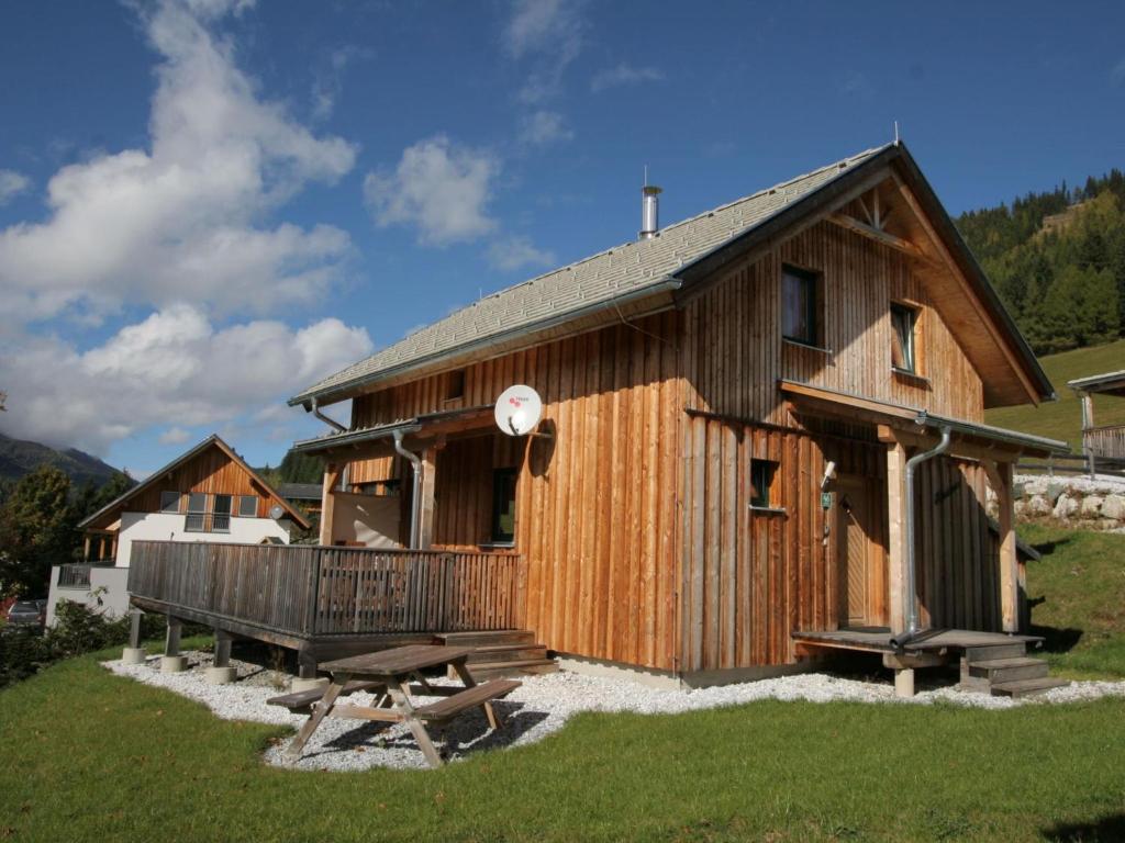 eine große Holzhütte mit einer Bank und einem Tisch in der Unterkunft Die Bergliebe in Hohentauern