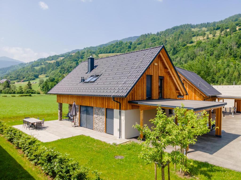 a wooden house in a field with mountains in the background at Mountain Vista in Sankt Lorenzen ob Murau