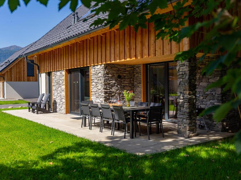 a patio with a table and chairs in front of a building at Mountain Chalet Dahoam in Sankt Lorenzen ob Murau