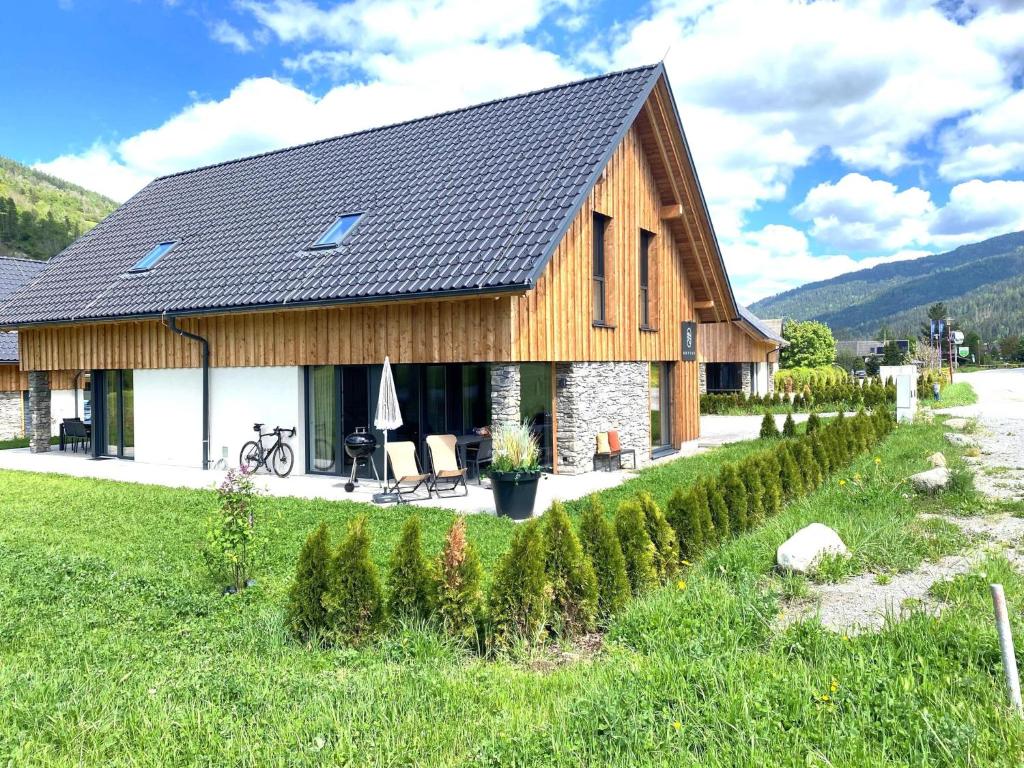 a large wooden house with a garden in front of it at Mountain Chalet Esttes in Sankt Lorenzen ob Murau