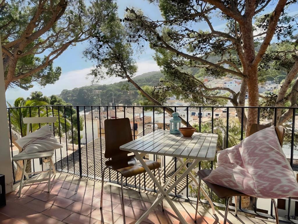 a patio with a table and chairs on a balcony at Stunning Intimate views. Terrace Rooftop. Wifi in Tamariu