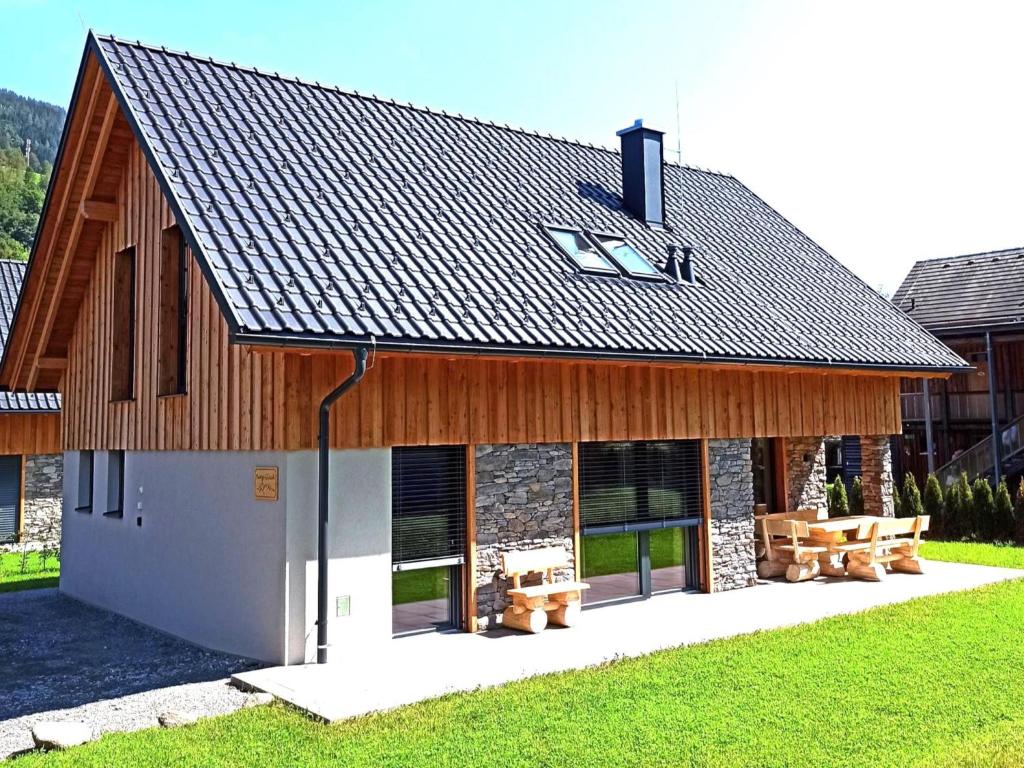 a large wooden building with benches in front of it at Mountain Chalet Berg-Glück in Sankt Lorenzen ob Murau
