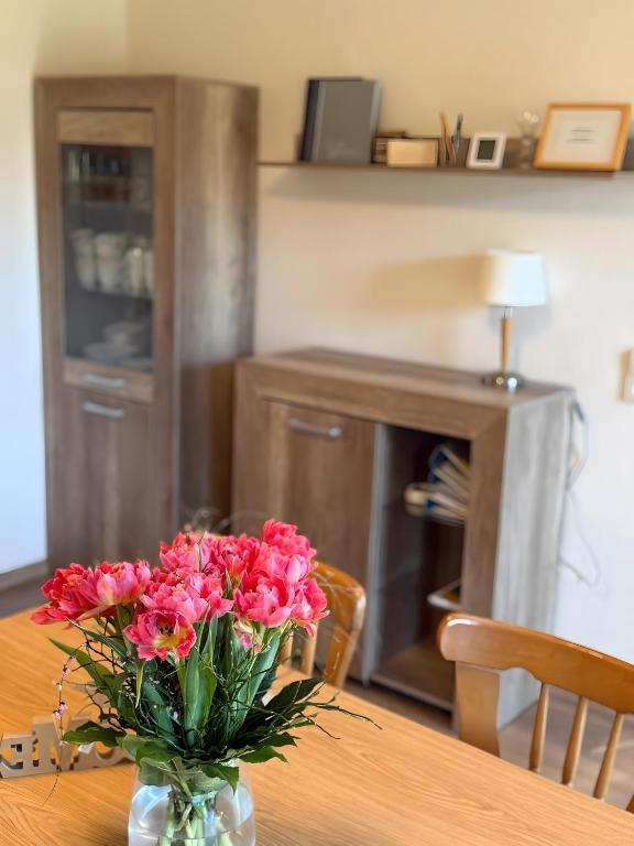 a vase of pink flowers sitting on a table at Wohnung mit Balkon im Schwarzwald in Seebach