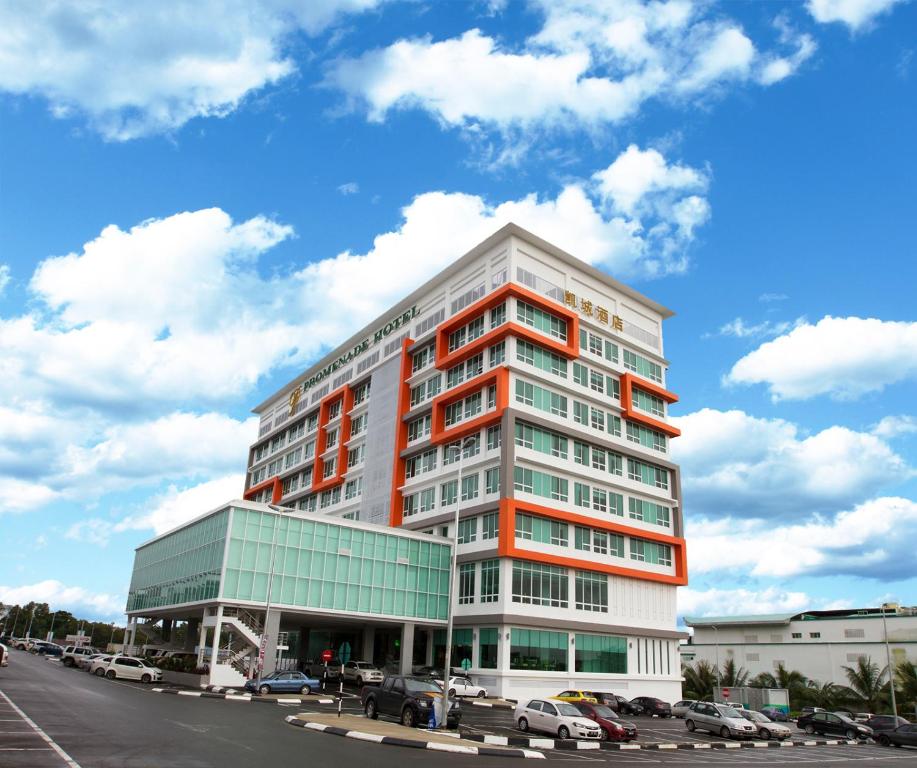 een hoog gebouw met een oranje en wit bij Promenade Hotel Bintulu in Bintulu