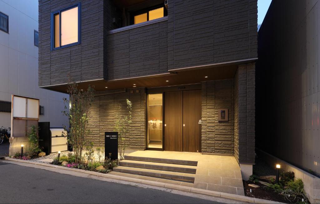 a house with a wooden door on the side of it at MOMIJI TERRACE Hiroshima in Hiroshima