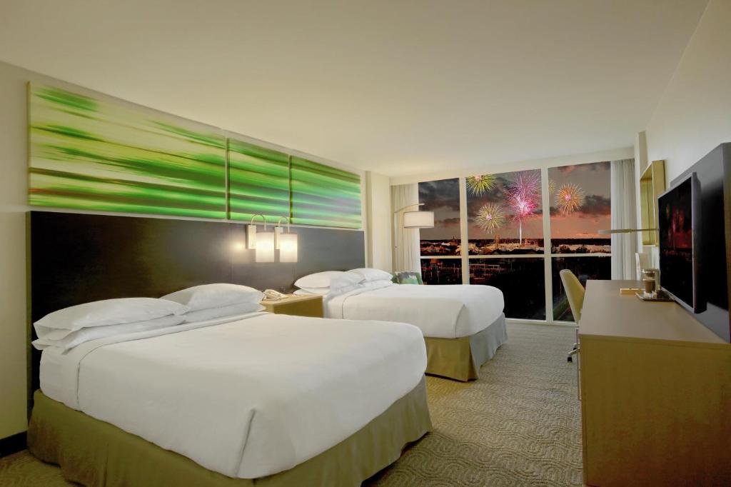 a hotel room with two beds and a television at DoubleTree by Hilton at the Entrance to Universal Orlando in Orlando
