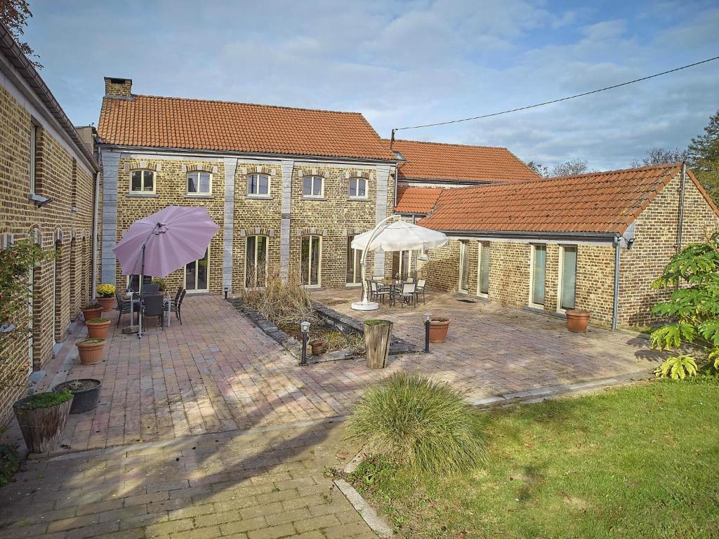 a brick building with two umbrellas in a courtyard at Quanto A in Geetbets