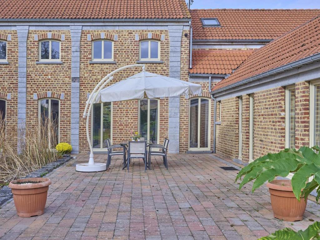 a patio with an umbrella and a table and chairs at Quanto B in Geetbets