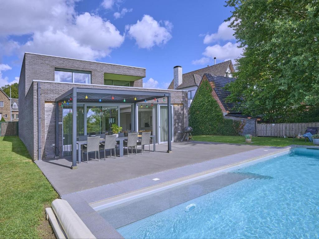 a house with a swimming pool next to a house at Maison Oscar in Tongeren