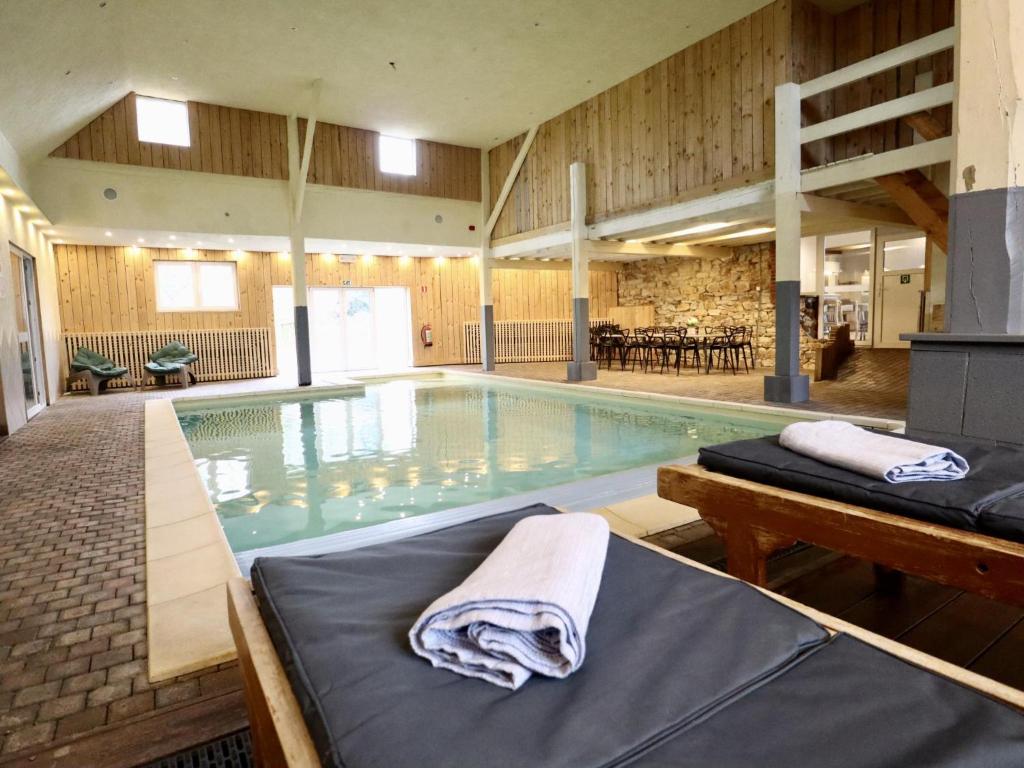 a large swimming pool with a bed in a building at Le GitAnne in Sourbrodt