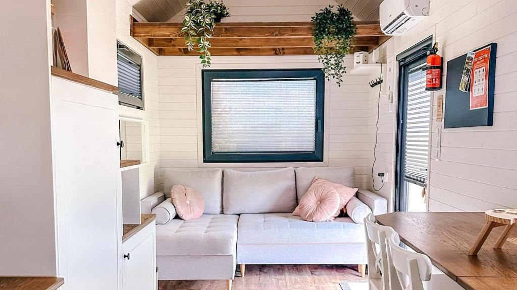 a living room with a couch in a tiny house at Dolce Casa 2 by Tiny Away in Rigutino