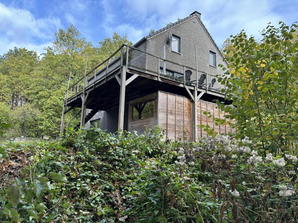 a house with a deck on the side of it at The Green in Durbuy