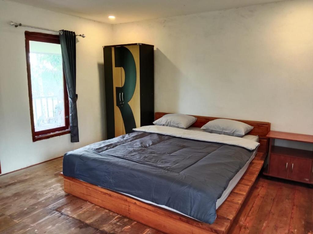 a bedroom with a large bed in a room at Benang Kelambu Cottage in Praya