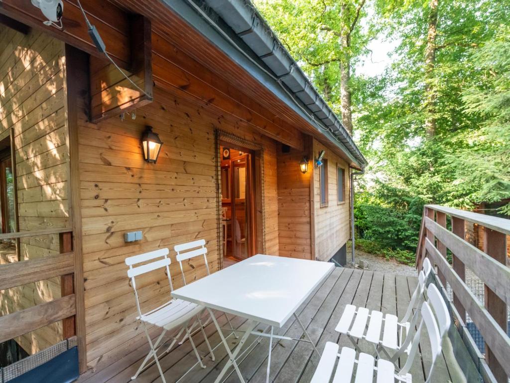 eine Holzterrasse mit einem weißen Tisch und Stühlen darauf in der Unterkunft lOrée in Biron