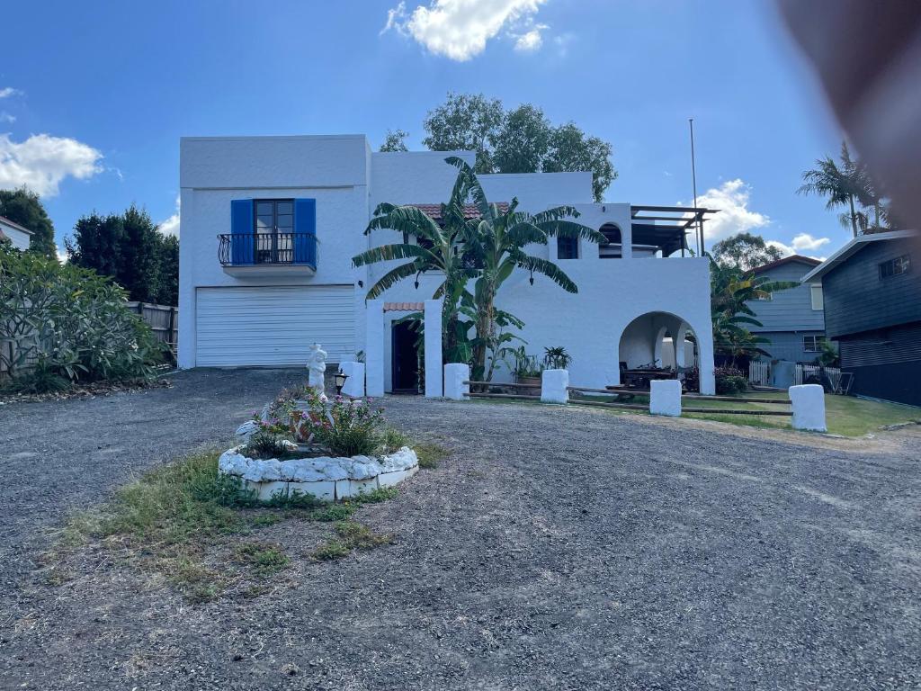 a white house with a palm tree in front of it at Villa on Ferguson in Ipswich