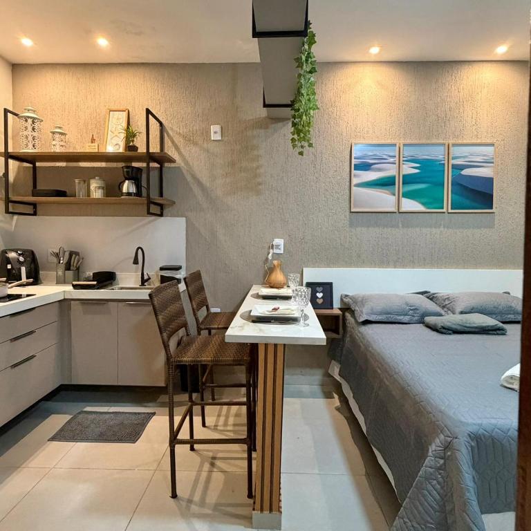 a bedroom with a bed and a table and a kitchen at VR VILLAGE - APT 02 - Studio completo próximo ao Shopping da Ilha in São Luís