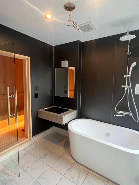 a bathroom with a bath tub and a sink at Nord SUR in Ichinomiya