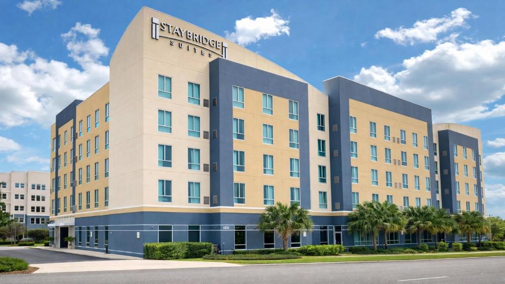 a hotel building with palm trees in front of it at Staybridge Suites St. Petersburg FL by IHG in St. Petersburg