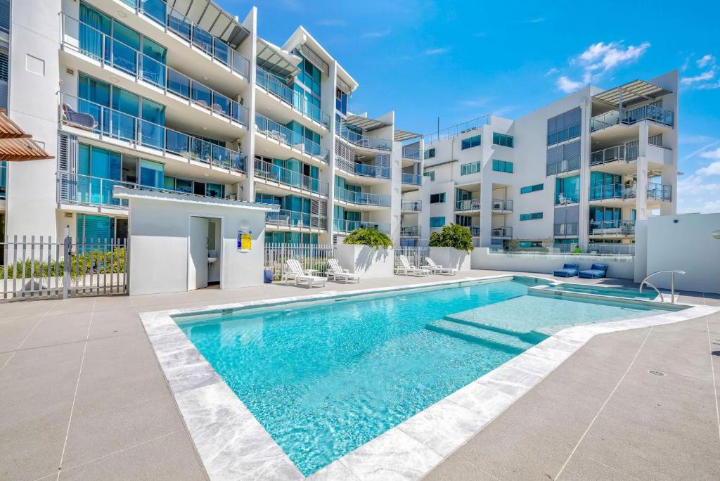 a swimming pool in front of a apartment building at Dwell Apartment 33 in Bargara