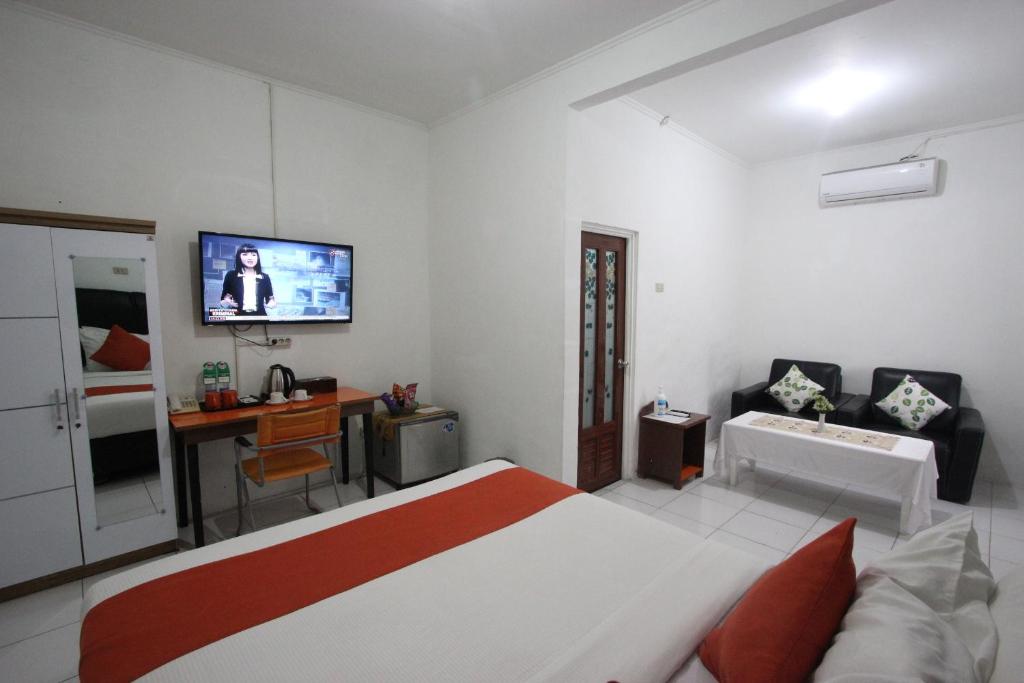 a bedroom with a bed and a tv on the wall at Yasminstar Hotel in Muntok