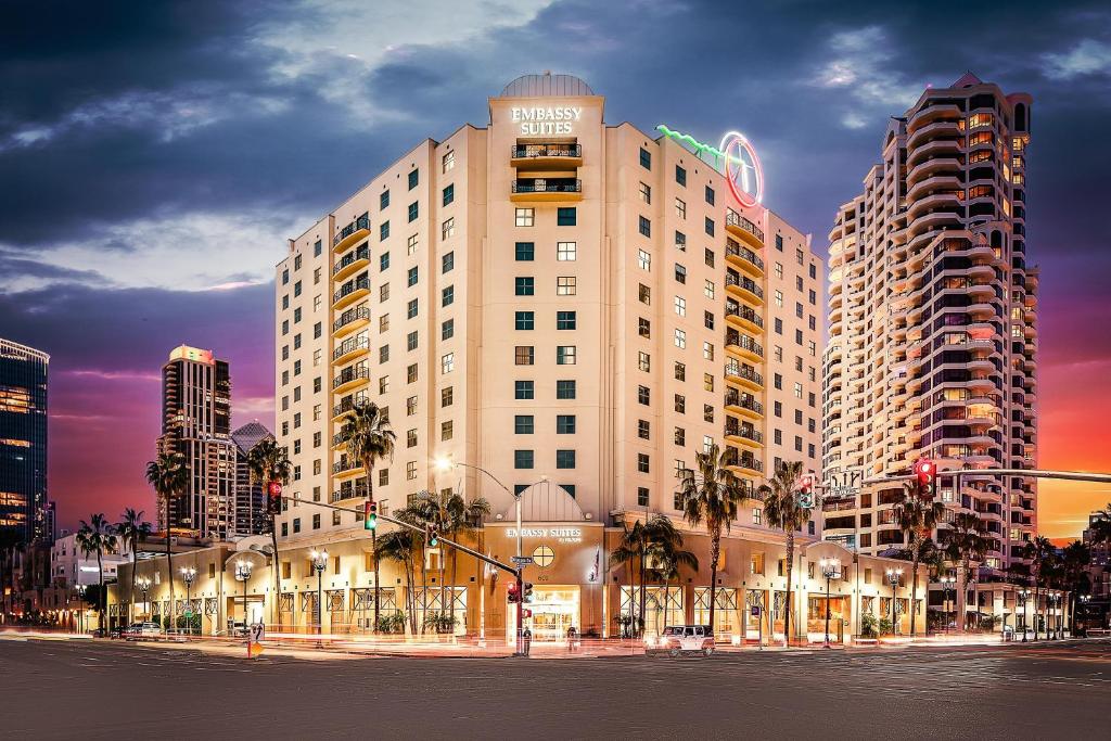 a tall building with palm trees in front of a street at Embassy Suites by Hilton San Diego Bay Downtown in San Diego