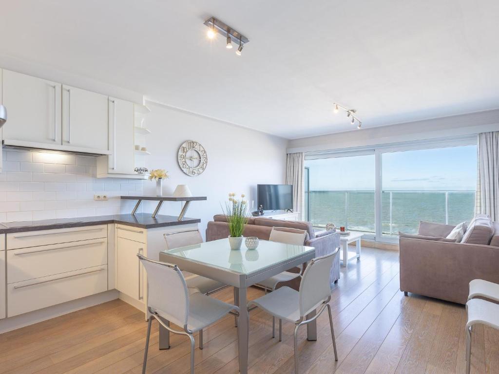 a kitchen and living room with a table and chairs at Romanza - 0405 + park.38 in Middelkerke