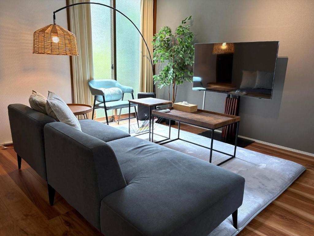 a living room with a couch and a table at Hook House Stay Kanazawa in Kanazawa
