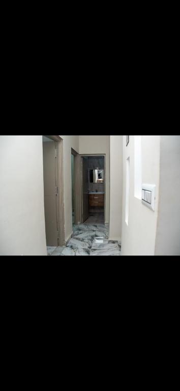 a room with a hallway with white walls at Le mirage in Tozeur