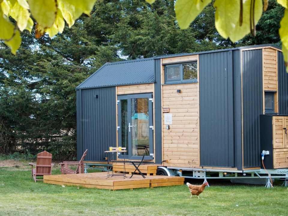 a tiny house on a trailer with a deck at Sugar Hut by Tiny Away in Great Horkesley