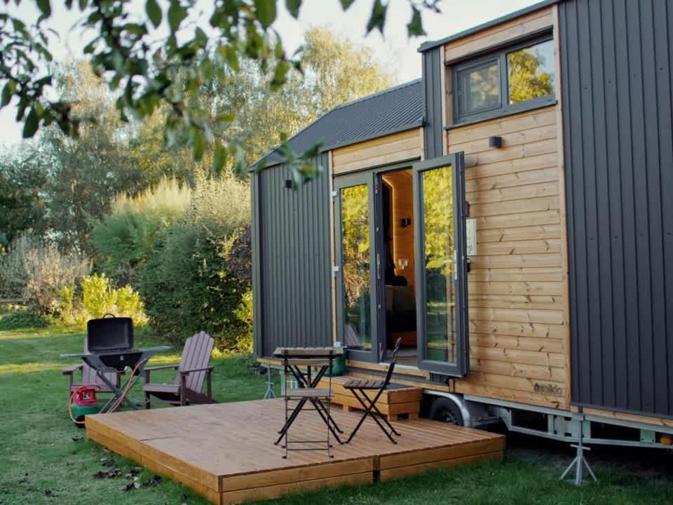 a tiny house with a deck and a grill at Vilasini Hut by Tiny Away in Great Horkesley
