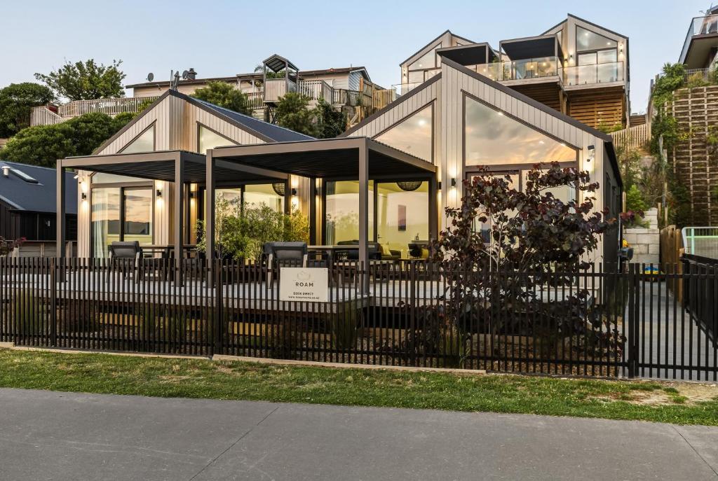a house with glass windows and a black fence at Roam Taupo Lakefront Combined Units 1&2 in Taupo