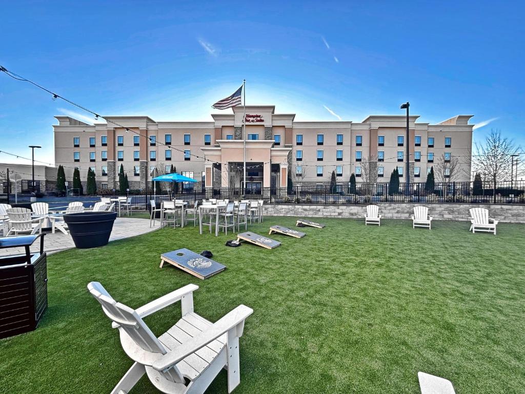 a large building with white chairs and tables in a yard at Hampton Inn and Suites Robbinsville in Robbinsville