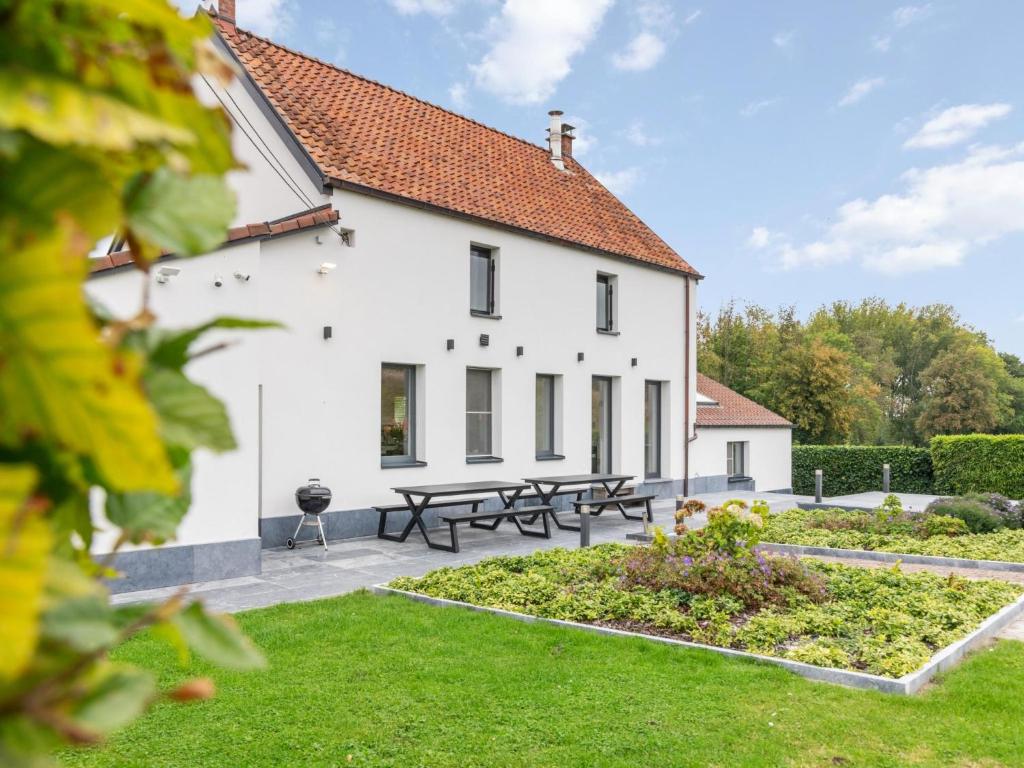 a white house with picnic tables in the yard at Landhuis Brakelbos in Brakel