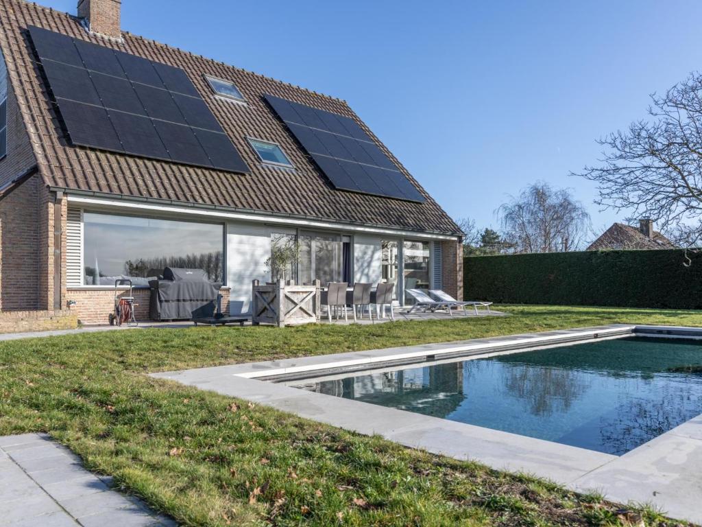 a house with solar panels on the roof at Maison Odille in Sint-Laureins