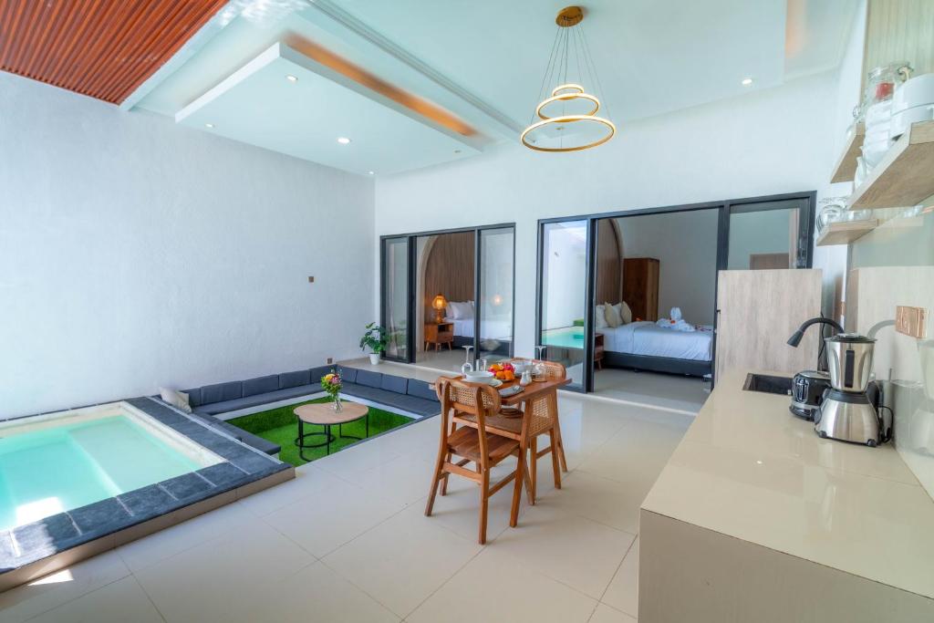 a kitchen and living room with a table and a pool at Ghania Villas Melasti in Ungasan