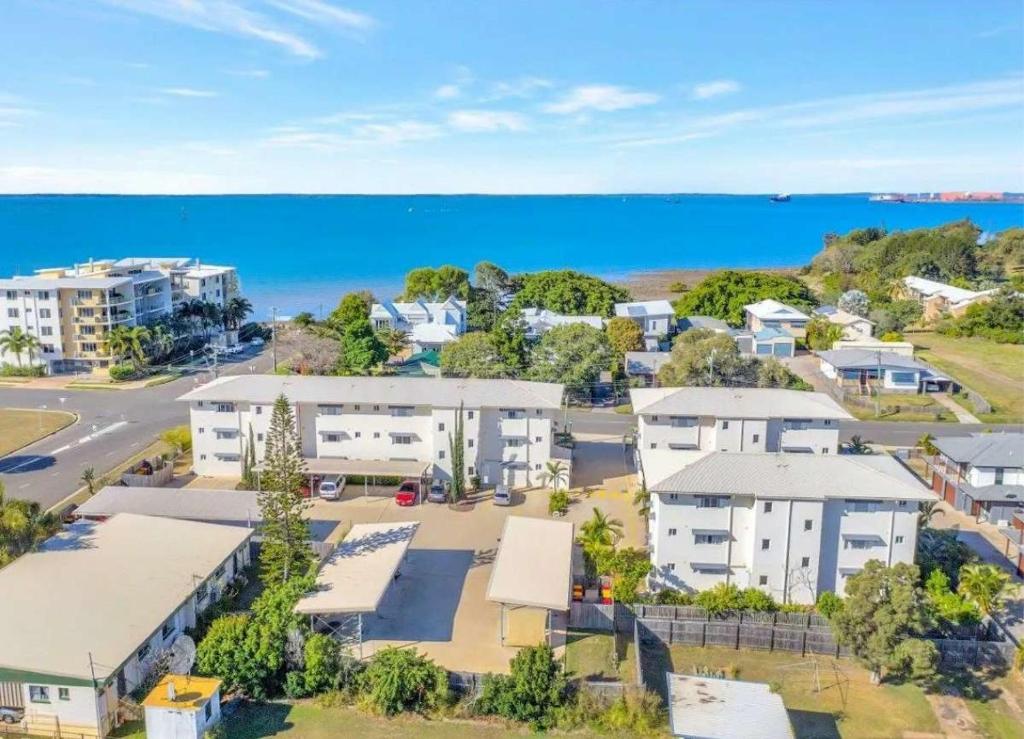 an aerial view of a suburb with houses and the ocean at Modern Beach Apartment in Gladstone