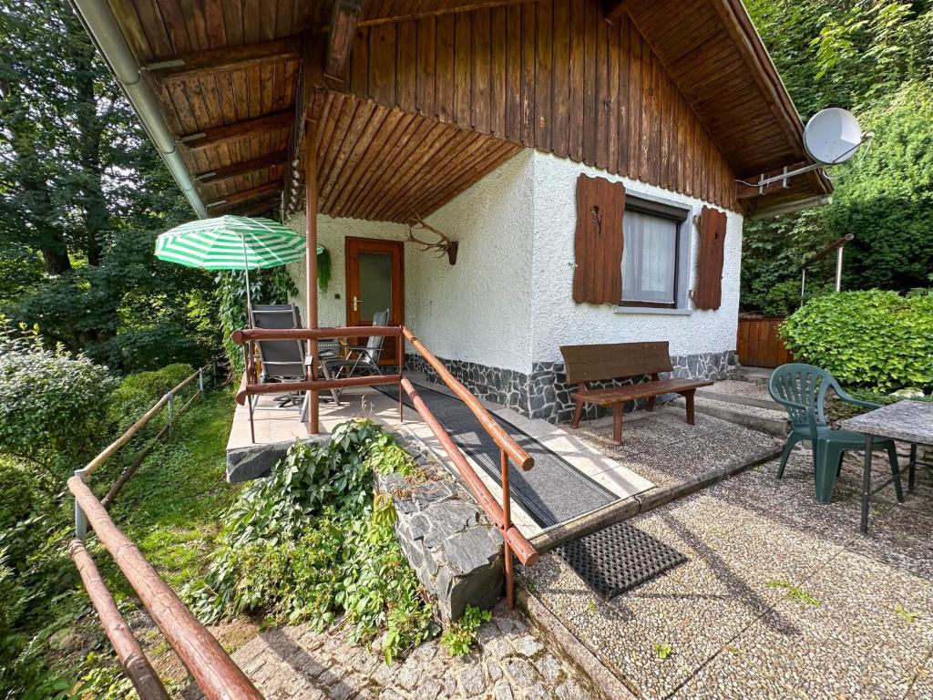 a house with an umbrella and a table and a bench at Knusperhäuschen in Engenstein