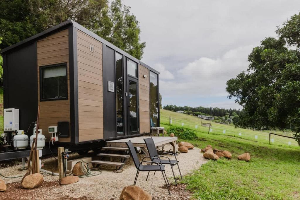 a tiny house on a trailer with a table and chairs at 8 Farm Macadamia Plantation 2 by Tiny Away in Cumbalum