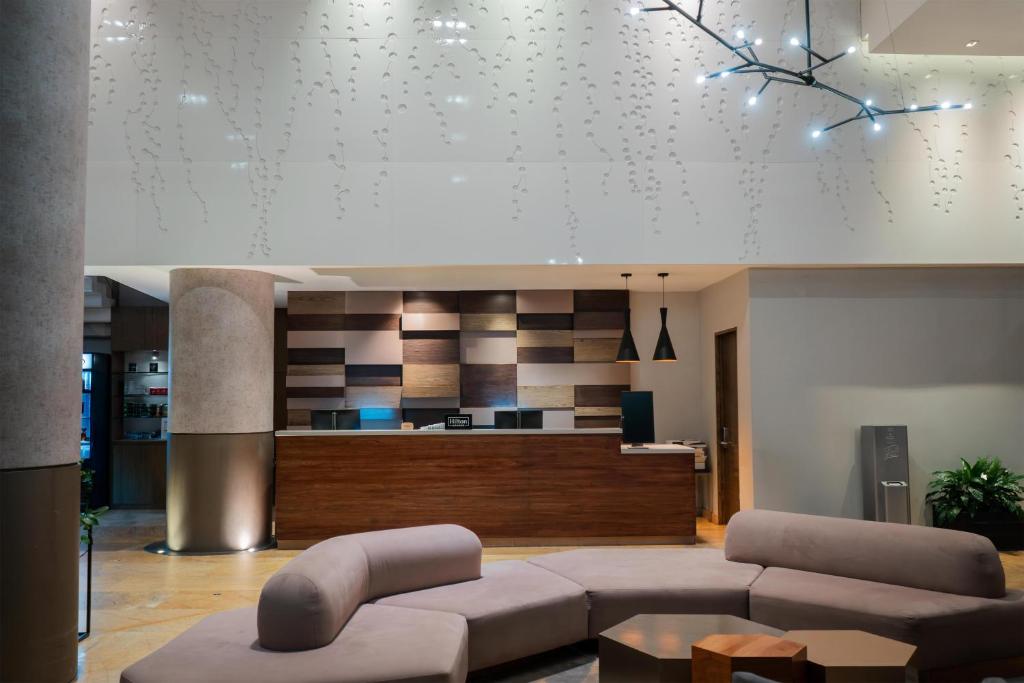 a living room with a couch and a kitchen at Doubletree By Hilton Mexico City Santa Fe in Mexico City
