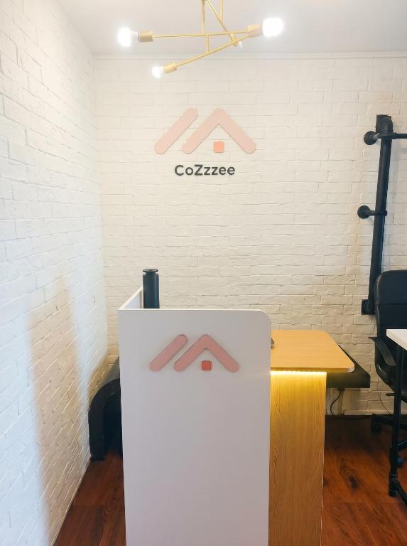 a white counter in a room with a white brick wall at CoZzzee Hostel in Singapore